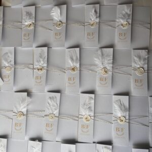 invitatie handmade personalizata cu coperta alba cu initialele mirilor pana sigiliu de ceara