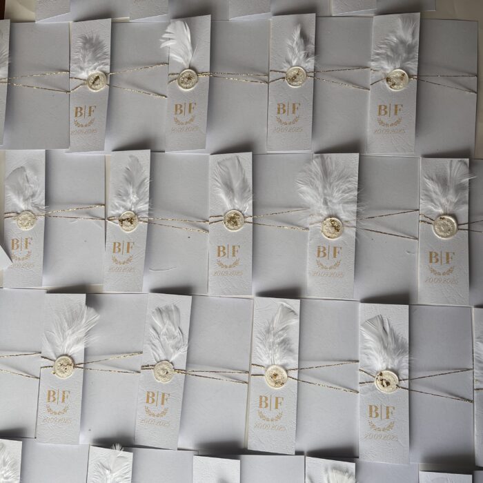 invitatie handmade personalizata cu coperta alba cu initialele mirilor pana sigiliu de ceara